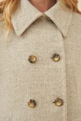 Chaquetón de lana fina color beige con cuello solapa, doble abotonadura frontal, bolsillos ojal y forro al tono.