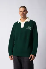 Sweater de punto verde con cuello polo color crema y bordado frontal con texto en blanco.
