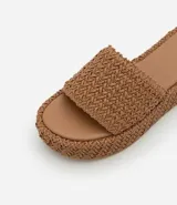 Sandalia flatform con superficie trenzada metalizada color dorado, sin cierre, con tira ancha y puntera redonda.