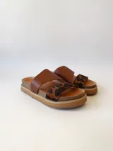 Sandalias bajas de cuero marrón con estampado animal print en las tiras.