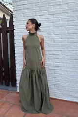 Vestido largo verde oliva de tela simil agamuzada, con escote halter, espalda baja y volados en cuello y cadera.