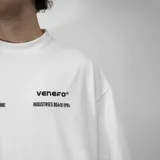 Remera blanca de algodón, corte oversize y manga corta, con estampado trasero en negro que incluye el logo "VENEFO TM", "Industries Company", "004@1994" y "WORLDTRIBE CO".