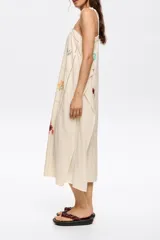 Vestido largo con estampado geométrico en tonos blanco, negro, rojo y marrón. Tiene tirantes finos y corte holgado.