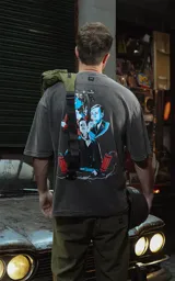 Remera negra con efecto nevado/acid wash, corte oversize, con estampado gráfico en la espalda inspirado en la película 'Bastardos sin gloria' de Tarantino, mostrando personajes con armas y dinamitas.