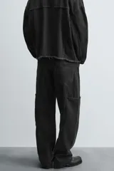 Pantalón relaxed fit confeccionado en denim de algodón color negro. Cuenta con bolsillos frontales, traseros de plastrón y bolsillos multifunción en las perneras. Tiene efecto lavado y cierre frontal con cremallera y botón.