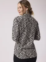 Camisa de manga larga con estampado de cebra en tonos beige, marrón y lila. Tiene cuello clásico, cierre con botones y un bolsillo en el pecho.