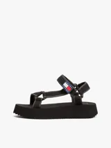 Sandalias de plataforma negras con suela dentada gruesa. Presentan tiras de tejido trenzado ajustables con velcro y un parche tonal con el logo de Tommy Jeans.