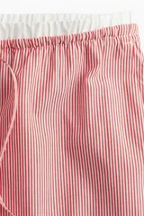 Pantalón de popelina de algodón a rayas rojas y blancas, con cintura elástica, cordón ajustable y bolsillos laterales.