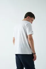 Remera color marrón con estampado rectangular con líneas horizontales y figura geométrica en el centro.