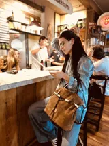 Bolso marrón de cuero gamuzado con correa bandolera de cuero marrón y detalle de cuero con estampado animal print.