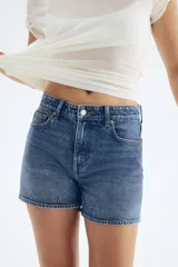 Short de jean azul de tiro alto, con cinco bolsillos y ruedo desflecado.