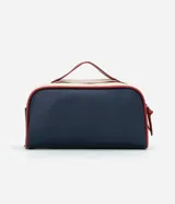 Neceser tipo baúl con dos compartimentos cerrados con cremallera, asa superior y tiradores. Diseño liso en azul marino y blanco con detalles en rojo.