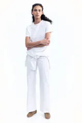 Remera blanca de algodón suave con cuello redondo ribeteado y bajo recto.