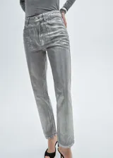 Pantalón de jean plateado de tiro alto, corte recto, con cierre de cremallera y botón, cinco bolsillos y trabillas.