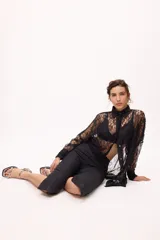 Pantalón capri negro con terminación en picos y costuras en color ladrillo.