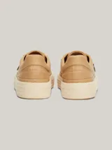 Zapatillas Tommy Hilfiger color beige de lino orgánico con monograma TH dorado en el lateral.