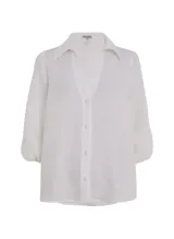 Camisa blanca de lino con cuello alto, escote en V, mangas 3/4 con volumen abullonado y puños elásticos.