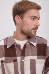 Sobrecamisa Jack & Jones de manga larga con cierre de botones, bolsillos en el pecho y corte relajado. Diseño a cuadros grandes en tonos marrón y beige.
