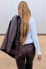 Pantalón de cuero marrón, de corte jeanero y piernas rectas.