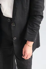 Blazer negro de corte clásico con solapas y cierre con botones.