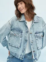 Campera de jean celeste con efecto lavado, corte cropped, cuello camisero, cierre frontal con botones metálicos, cuatro bolsillos frontales con solapa y puños abotonados.