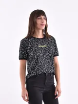 Remera negra con estampado de estrellas blancas y texto amarillo.
