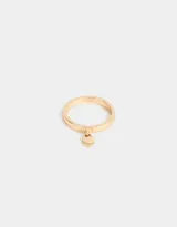 Anillo dorado con dije colgante en forma de corazón.