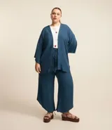 Pantalón pantacourt azul petróleo, de viscosa, con cintura elástica y lazo decorativo con borlas.