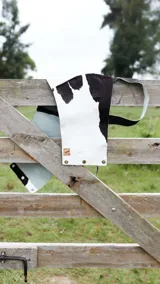 Top corto de cuero ovino con estampado de vaca en blanco y negro, con breteles anchos.