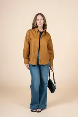 Camisa marrón de corte clásico, con tejido suave y textura cálida. Tiene un bolsillo decorativo discreto y botones al tono.