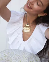 Collar con dije grande de bronce con forma de ostra y cordón de algodón ajustable color gris.