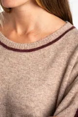 Sweater de punto azul marino con calce oversize. Presenta un detalle de franja vertical color marrón en la parte exterior de ambas mangas y un ribete fino dorado en el escote redondo.