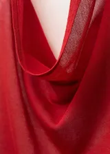 Top rojo de punto fino con cuello halter drapeado y espalda descubierta. Presenta un cinturón tipo lazo en la cintura, bajo asimétrico y cierre de botones en el cuello.