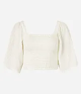Blusa cropped color blanco, con escote recto, mangas amplias con elástico en los hombros, lastex en el cuerpo y textura.