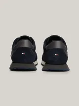Zapatillas Tommy Hilfiger de estilo running, color azul marino con detalles en rojo, blanco y gris. Confeccionadas en poliéster con interior de poliéster, plantilla extraíble de goma termoplástica y poliuretano, y suela de goma dentada. Presentan cinta distintiva en el lateral, paneles con mezcla de texturas y parche con logo en la lengüeta.