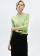 Buzo de punto fino color verde claro, con cuello redondo y mangas largas.
