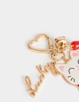 Llavero metálico con dije esmaltado de gatito de la suerte, cascabel y pimiento rojo. Incluye mosquetón en forma de corazón y dije con la palabra "Lucky".