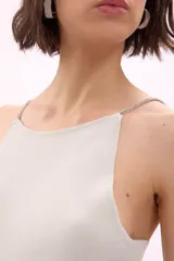 Blusa tejida color lila con cuello halter y detalle de strass en los tirantes.