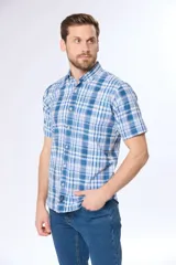 Camisa de manga corta con cuello abotonado y estampado a cuadros en tonos de azul y blanco. Hecha en Uruguay.
