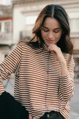 Polera de punto a rayas horizontales color celeste y blanco, de cuello alto y mangas largas.