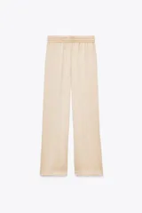 Pantalón de tiro alto color beige con cintura elástica ajustable con cordones, bolsillos delanteros y pernera ancha.