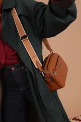 Bandolera color mostaza de simil cuero, con tres cierres principales, cierre delantero y bolsillo trasero. Incluye correa ajustable.