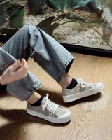 Zapatillas de lona celeste con cordones blancos y suela blanca.