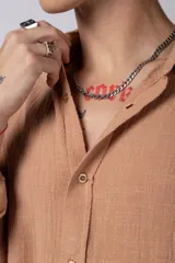 Camisa blanca de lino con cuello clásico, manga larga con puños abotonados y corte holgado. 