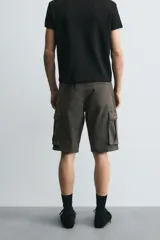 Bermuda cargo de algodón color marrón oscuro, tiro medio, corte regular, con bolsillos laterales de parche con solapa y bolsillos traseros de vivo.