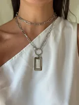 Collar plateado de cadena con eslabones grandes y dije rectangular con centro de nácar. Incluye un collar corto de cadena con eslabones más pequeños.