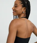 Blusa frente única color beige, con escote cuadrado y bretel ajustado en el cuello. Confeccionada en microfibra, es sin mangas y de corte ajustado.