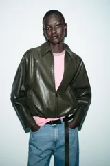 Chaqueta estilo bomber de efecto piel en color verde oliva, con cuello solapa, cierre frontal con cremallera, mangas largas y bajo con acabado elástico.