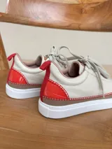 Championes de cuero color beige con puntera de gamuza marrón y costuras rojas.