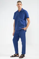 Camisa azul de manga corta confeccionada en algodón ligero con textura waffle. Presenta un corte cuadrado, bolsillo en el pecho y botones de coco con el logo de Polonio.